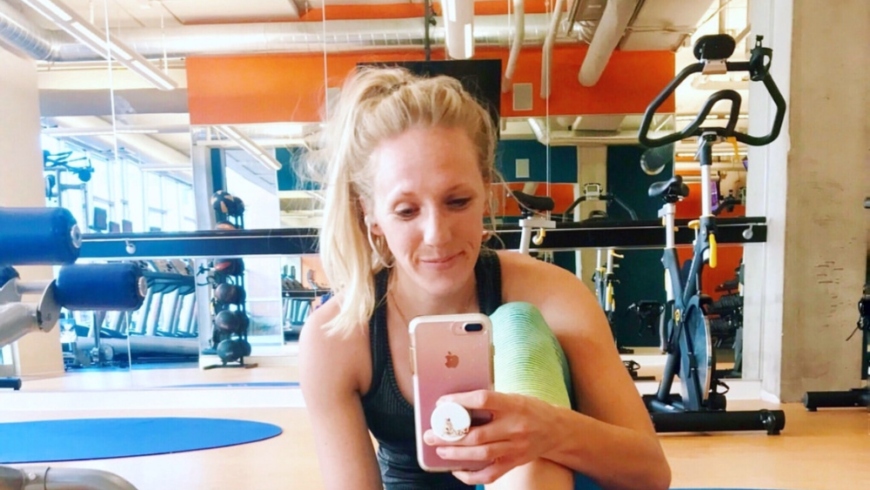 Girl taking a selfie in front of a mirror at the gym